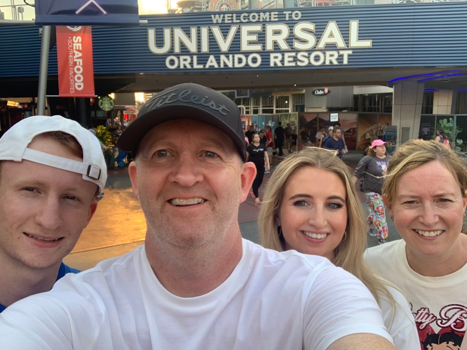 Family selfie in front of Universal Orlando Resort sign.