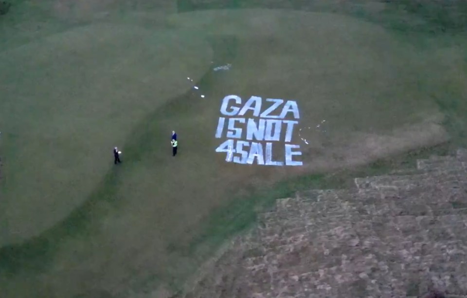 Aerial view of Trump Turnberry golf course with "GAZA IS NOT 4 SALE" painted on the lawn.