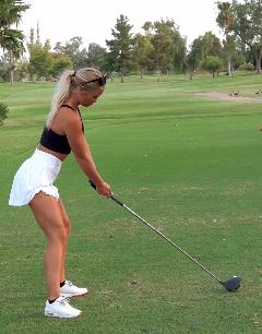 Woman golfing on a green.