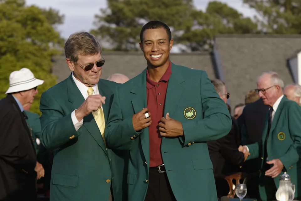 Tiger Woods is presented with his green jacket by Augusta National Golf Club chairman Hootie Johnson after Tiger won the 2002 Masters Tournament.