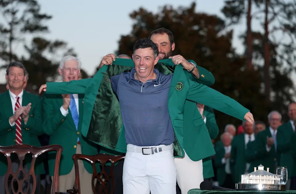 Rory McIlroy of Northern Ireland is given his green jacket. Getty Images