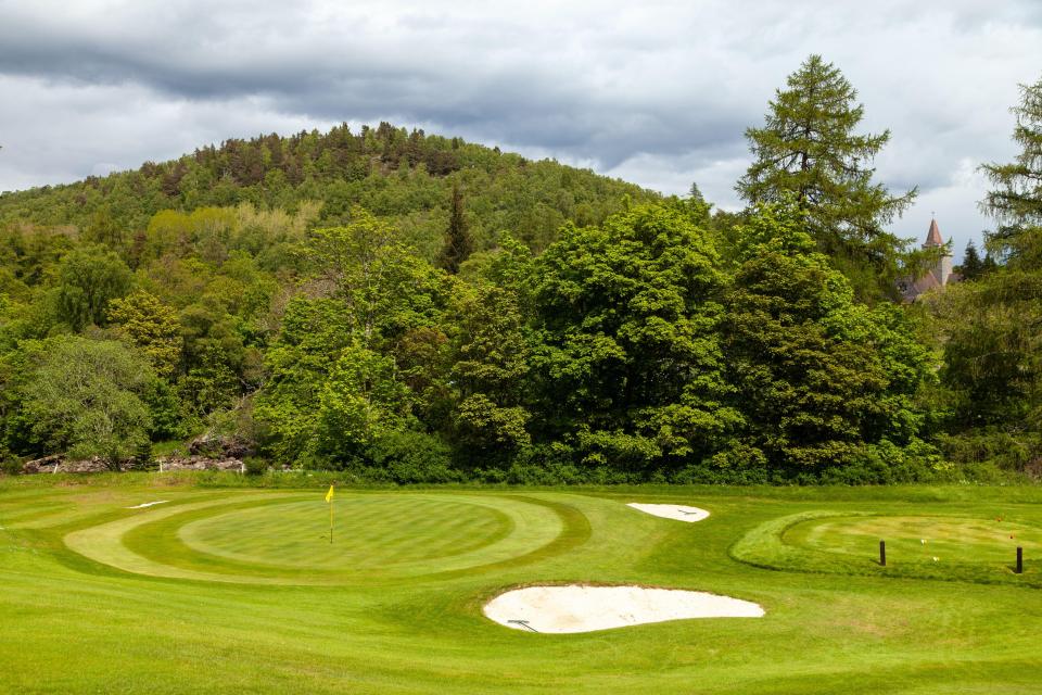 Balmoral Castle Golf Club green with sand traps and trees.