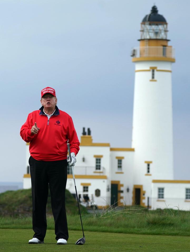 Donald Trump playing golf with a lighthouse in the background.