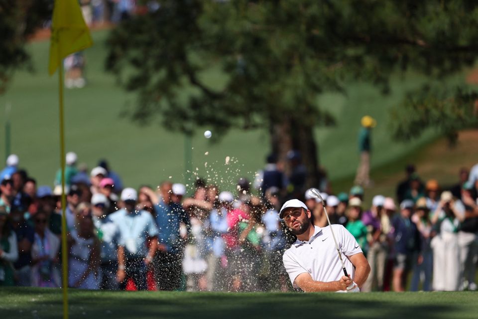 Defending champion Scottie Scheffler plays out from the bunker on the seventh hole during the first round of the Masters at Augusta. Photo: Mike Segar/Reuters