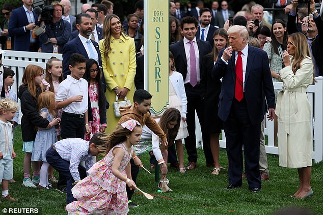President Donald Trump and first lady Melania Trump (right) participate in the egg roll game alongside Donald Trump Jr. and girlfriend Bettina Anderson (left)