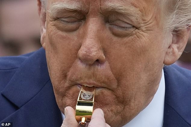 President Donald Trump blows a whistle during Monday's White House Easter Egg Roll on the South Lawn