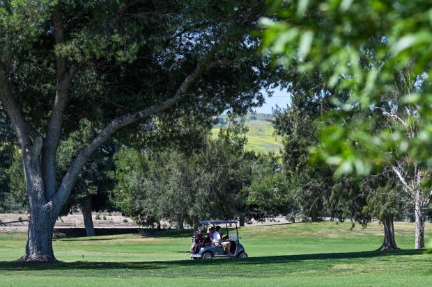Golfers drive through the El Prado Golf Course on Tuesday,...