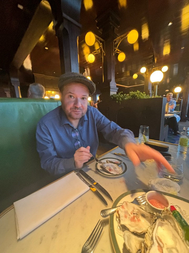 Man eating oysters in a restaurant.