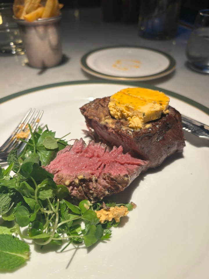 Seared steak with herb butter and greens.