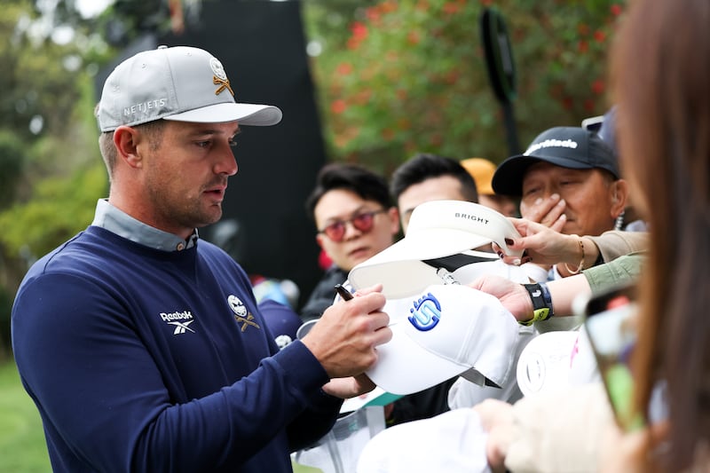 HONG KONG, CHINA - MARCH 07: Bryson DeChambeau of Crushers GC signs for fans after the match on the 1st hole on day one of LIV Golf Hong Kong at The Hong Kong Golf Club on March 07, 2025 in Hong Kong, China. (Photo by Zhizhao Wu/Getty Images)
