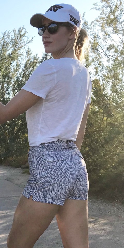 Woman in white shirt and patterned shorts, viewed from behind.