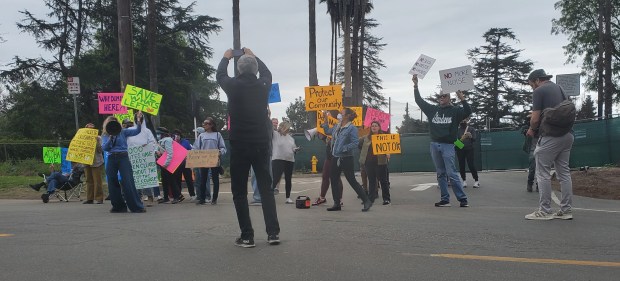 John Newell, in black, takes a picture of fellow protesters...