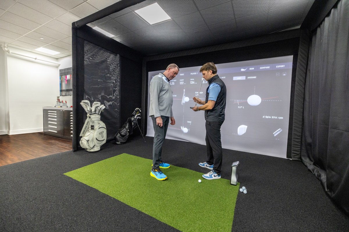 a True Spec Golf employee works with a customer in store,
