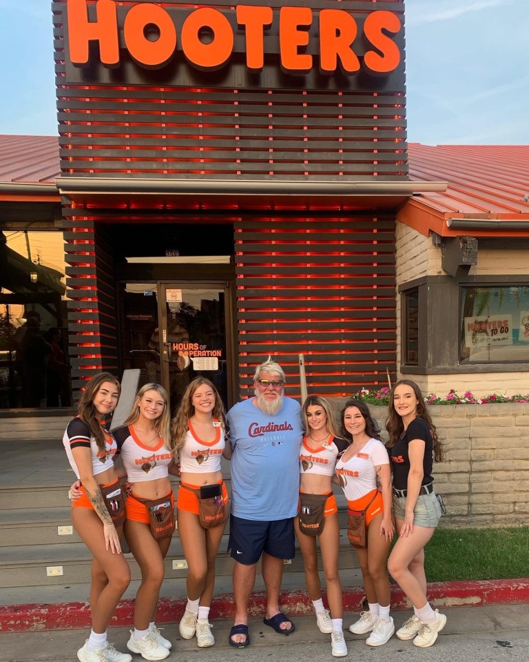 John Daly with Hooters waitresses outside a Hooters restaurant.