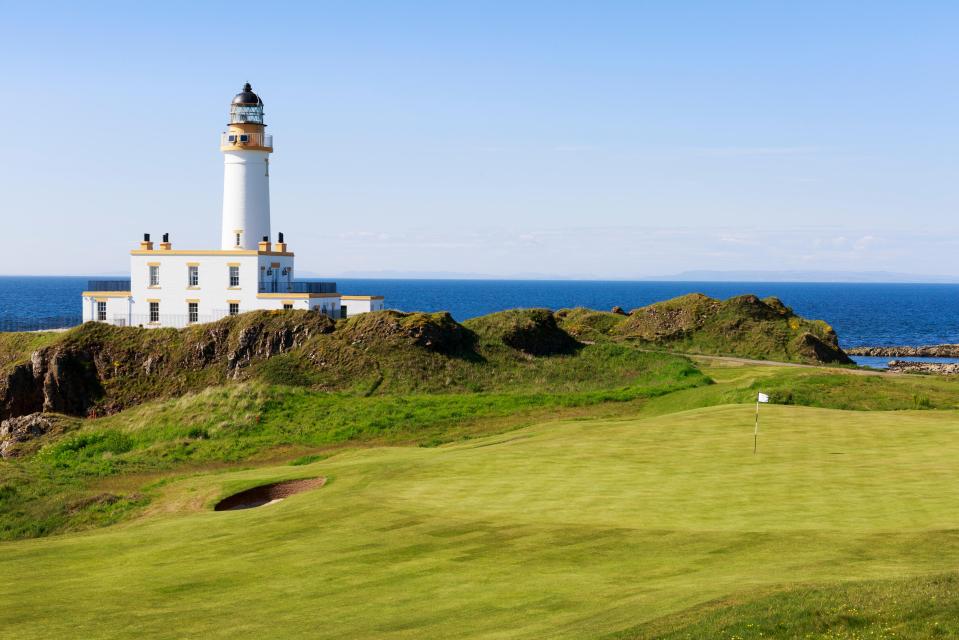 Lighthouse on a golf course overlooking the ocean.