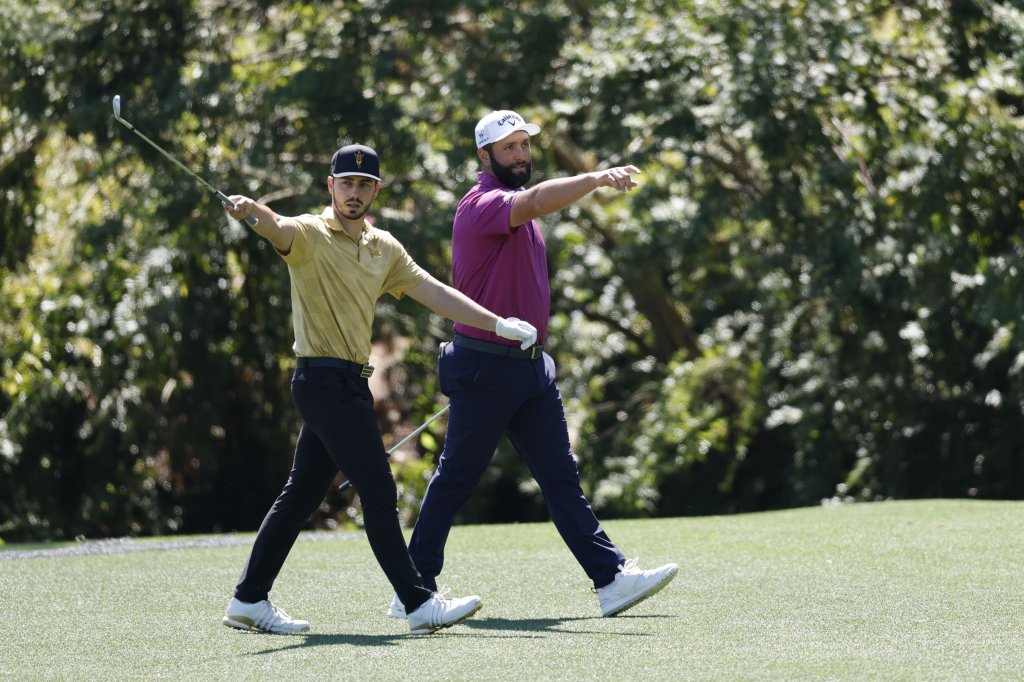 Jose Luis Ballester of Spain (L) and Jon Rahm of Spain (R) on the 13th green during a practice round for the 2025 Masters Tournament