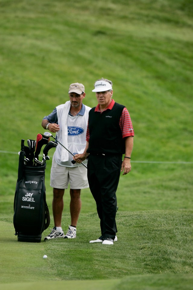 Jay Sigel on a golf course with his caddy.
