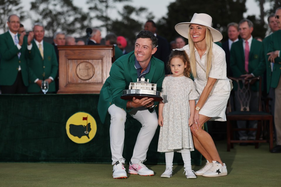 Rory McIlroy with his wife and daughter, holding the Masters trophy.