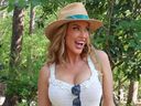 Paige Spiranac smiles for a photo while attending the Masters.