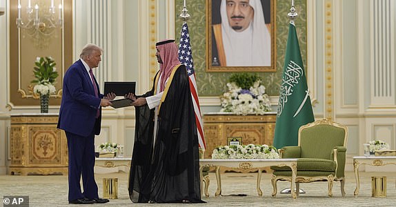President Donald Trump and Saudi Crown Prince Mohammed bin Salman exchange documents during a signing ceremony at the Royal Palace, Tuesday, May 13, 2025. (AP Photo/Alex Brandon)