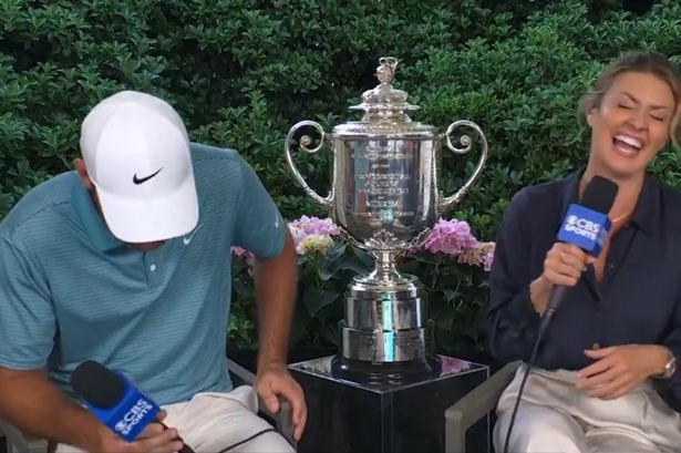 Scottie Scheffler coughing during an interview with Amanda Balionis