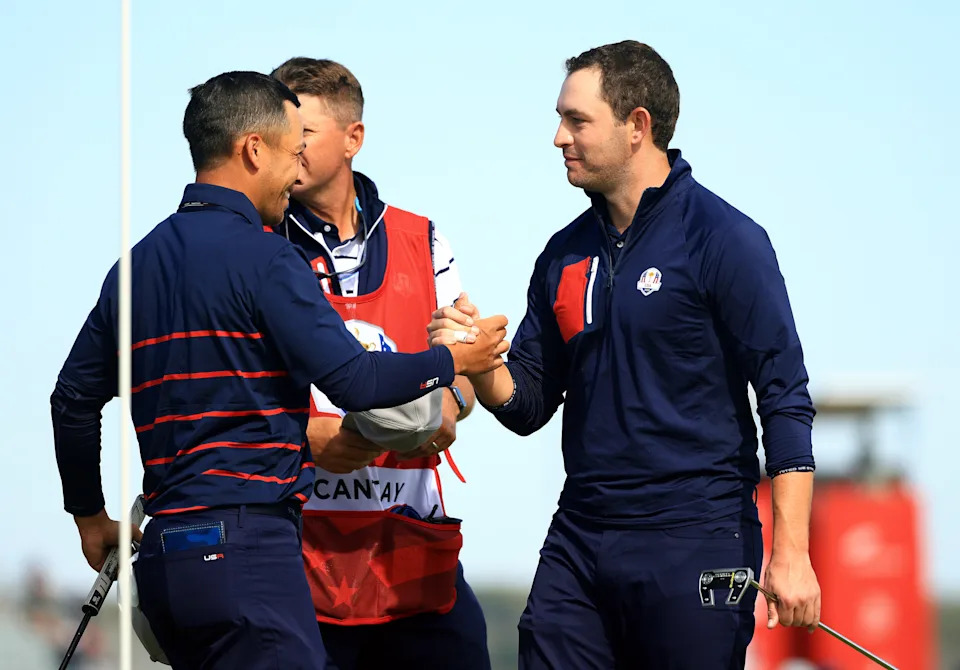 Xander Schauffele of team United States and Patrick Cantlay of team United States shake hands on the 15th green during Friday Morning Foursome Matches of the 43rd Ryder Cup at Whistling Straits on September 24, 2021 in Kohler, Wisconsin. (Photo by Mike Ehrmann/Getty Images)