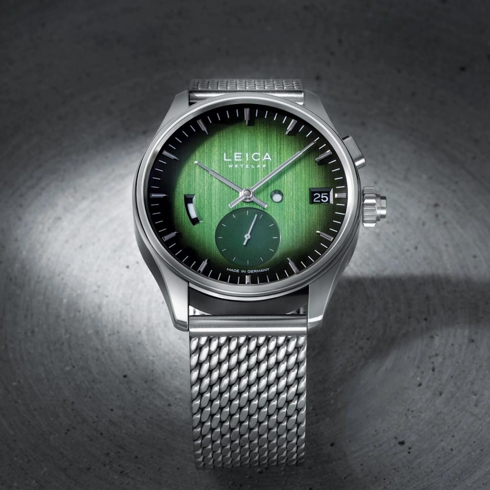 a steel watch with a green dial