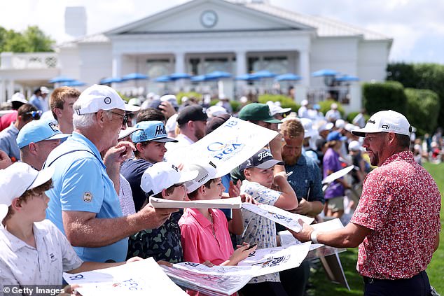 The 48-year-old is mobbed by fans looking for signatures ahead of the opening round