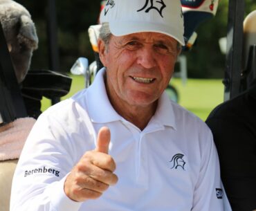 Gary Player swinging golf club on the course, smiling