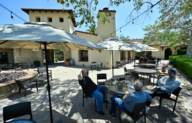 Visitors eat outside the clubhouse at Oak Creek Golf Club...