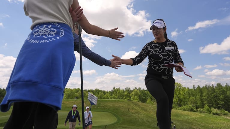 A Lim Kim, of South Korea, greets fans walking to the third tee during the first round.