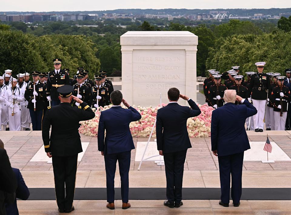 US President Donald Trump (R), US Vice President JD Vance (2R), US Secretary of Defense Pete Hegseth (2L), and MG Trevor Bredenkamp, Commanding General of the Joint Task Force-National Capital Region and the US Military District of Washington, salute before laying a wreath at the Tomb of the Unknown Soldier in Arlington National Cemetery in Arlington, Virginia, on Memorial Day, May 26, 2025.