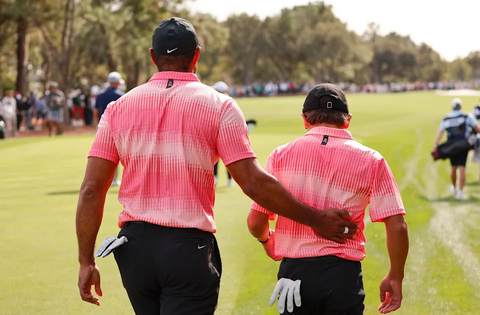 Charlie Woods and father Tiger Woods (left) walk off the first tee during the first round of the PNC Championship golf tournament at Ritz Carlton Golf Club Grande Lakes Orlando Course. Mandatory Credit: Reinhold Matay-USA TODAY Sports