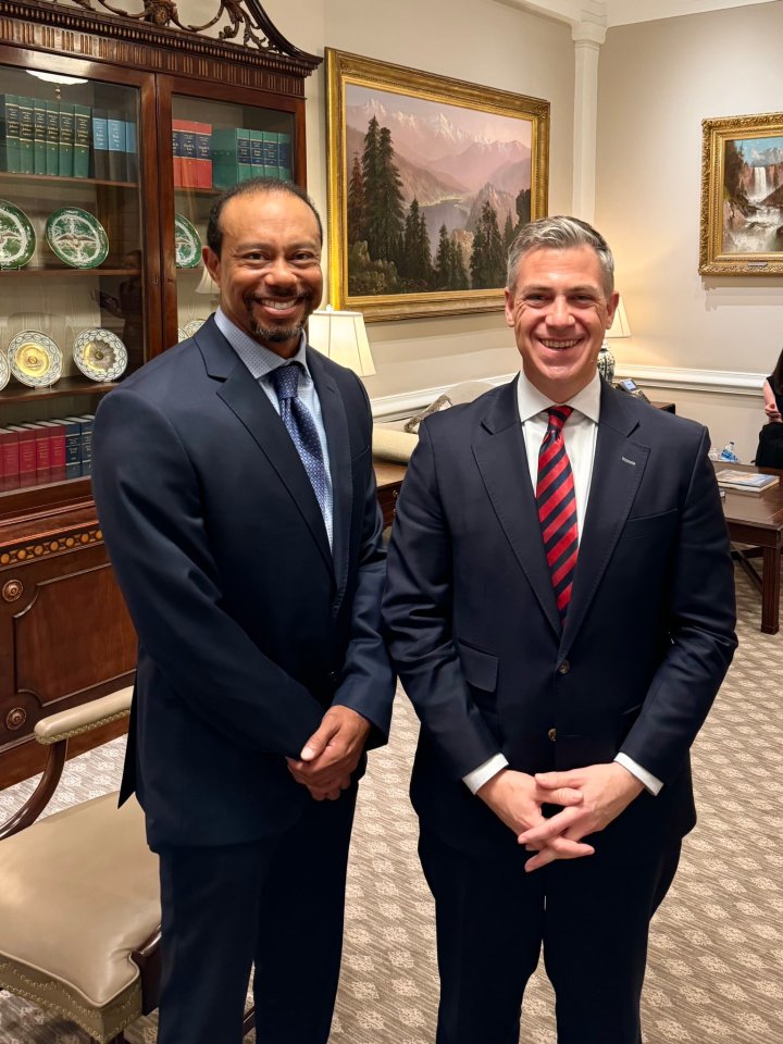 Tiger Woods and another man in suits at the White House.