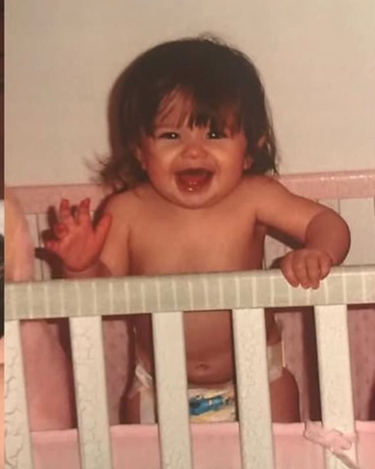 Baby girl smiling in crib.