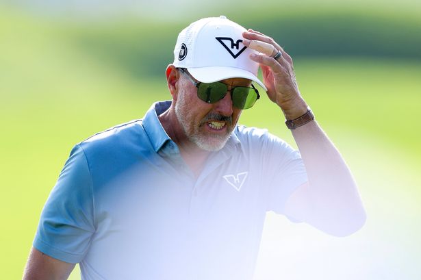 Phil Mickelson touches his hat with his hand