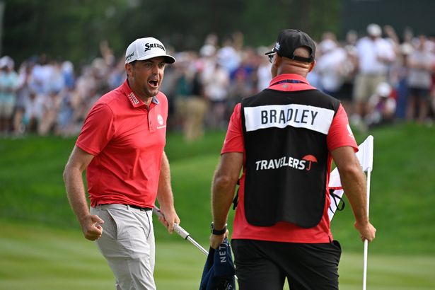  Keegan Bradley reacts to making the winning putt on the 18th green with his caddie, Scott Vail, during the final round of the Travelers Championship