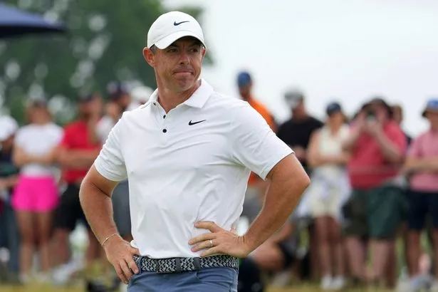 Rory McIlroy looks dejected with his hands on his hips on the green