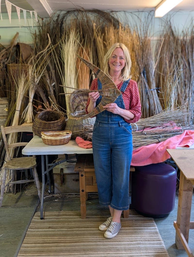 Louise McClean in her her studio, holding a swallow made from willow
