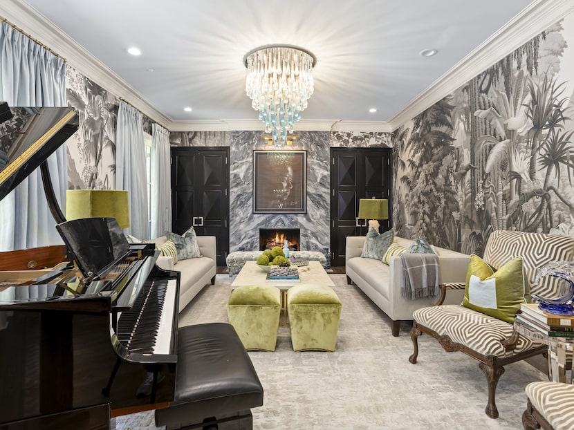 Formal living room with black and white wallpaper, piano and animal-print chairs