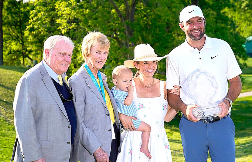 Scottie Scheffler, right, holds the trophy as he poses for a photo with his wife Meredith,...
