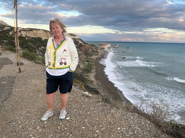 Woman standing on a cliff overlooking the ocean.