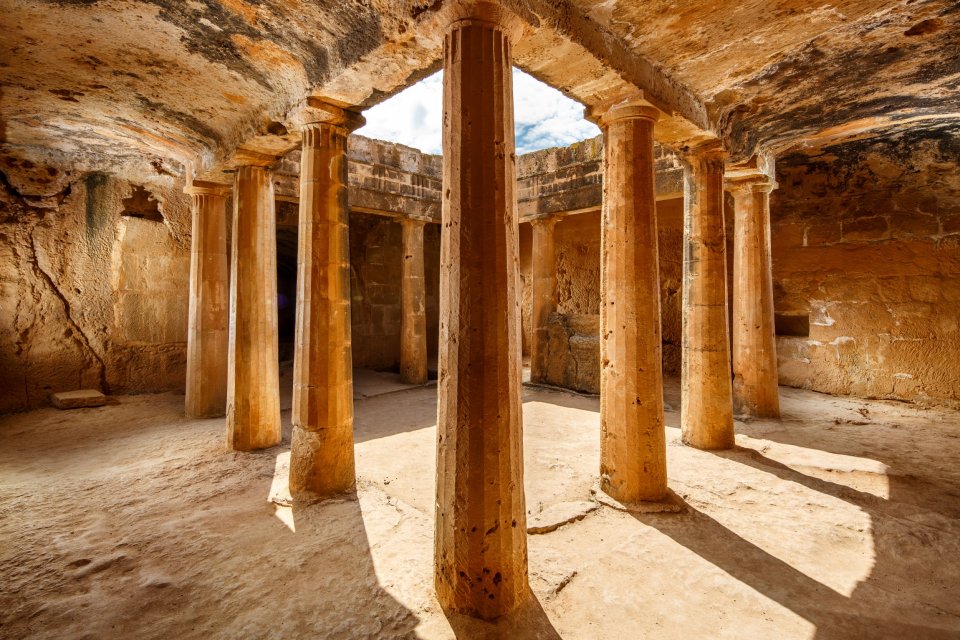 Interior of an ancient stone tomb with columns.