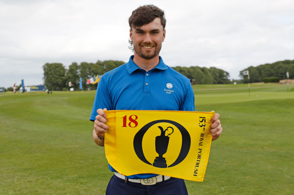 Golfer holding a yellow flag marking the 18th hole at Royal Portrush.