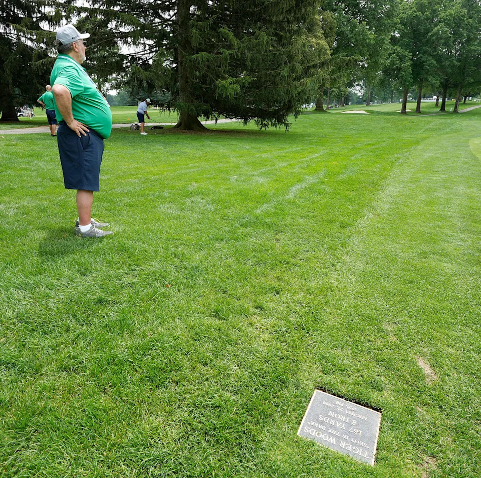 Glenn Duncan, a volunteer marshall for 32 years, stands near the plaque that marks the spot where Tiger Woods took the "Shot in the Dark" in 2000. Duncan talked about the shot during the Kaulig Companies Championship: Pro-Am at Firestone Country Club on June 18, 2025, in Akron.