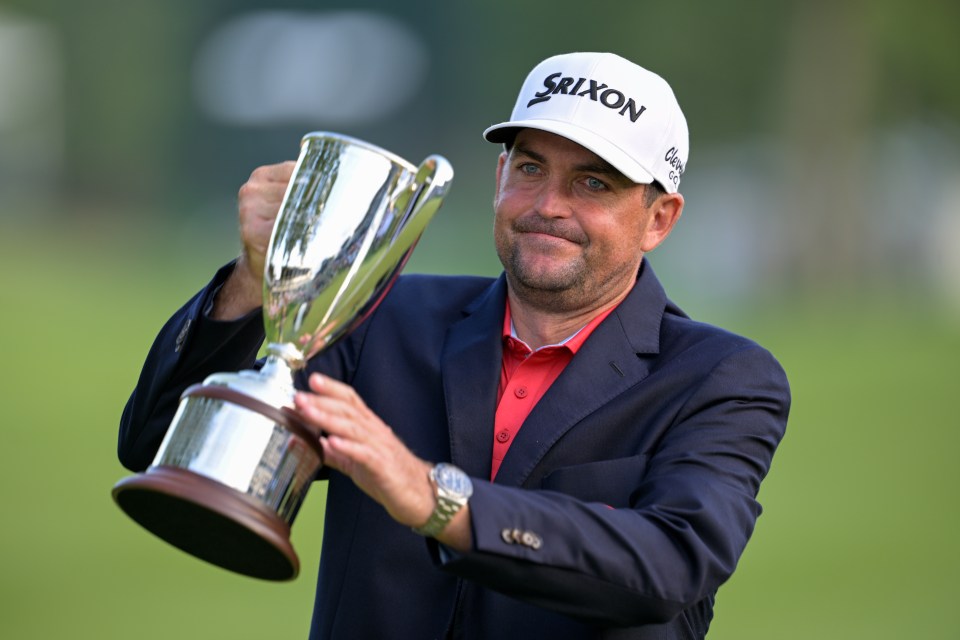 Keegan Bradley holding a trophy after winning a golf tournament.
