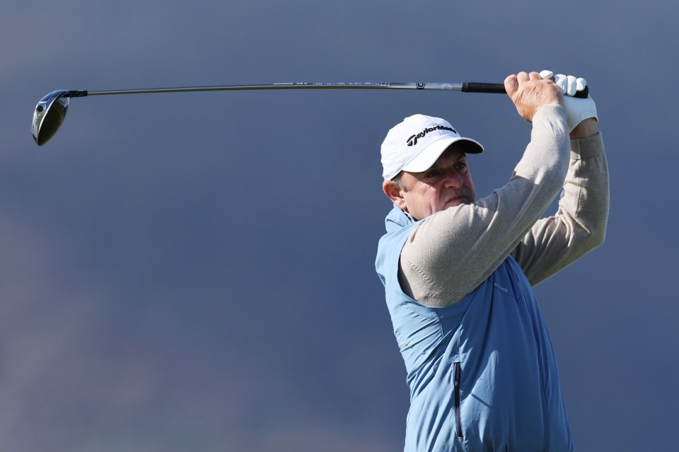 Paul McGinley teeing off at a golf tournament.