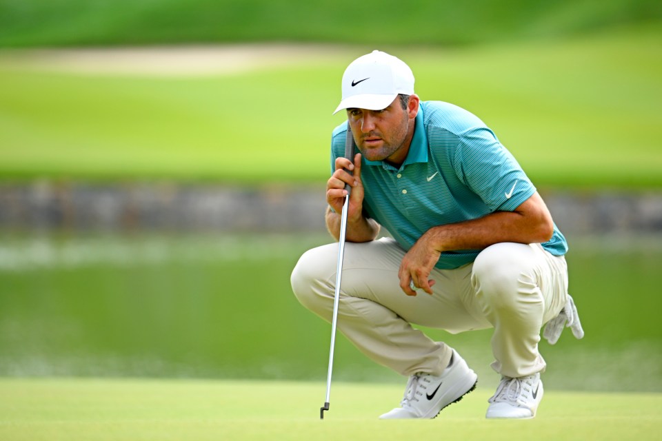 Scottie Scheffler lining up a putt on a golf green.