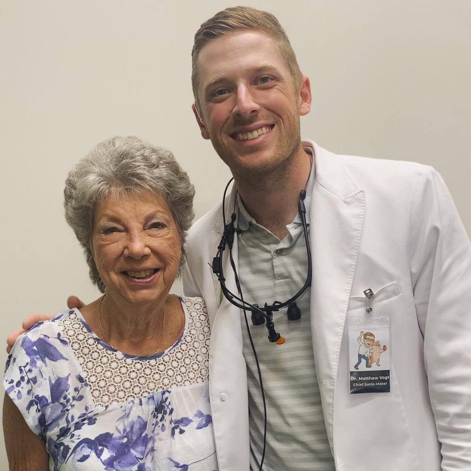 A dentist and a patient smiling together.