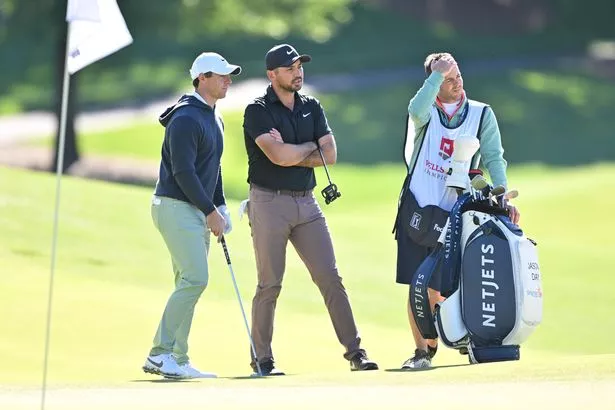 Rory McIlroy of Northern Ireland and Jason Day of Australia stand together on the 15th green during the first round of the Wells Fargo Championship at Quail Hollow Club on May 4, 2023